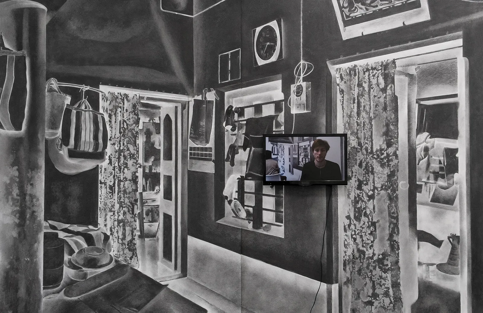 Installation view of Turning Back, a large charcoal drawing of an interior domestic space with a video screen installed on top of the drawing.