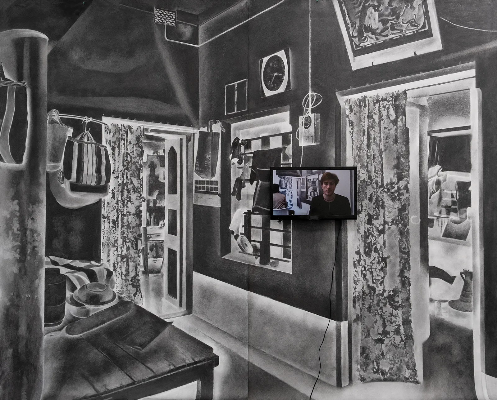 Installation view of Turning Back, a large charcoal drawing of an interior domestic space with a video screen installed on top of the drawing.