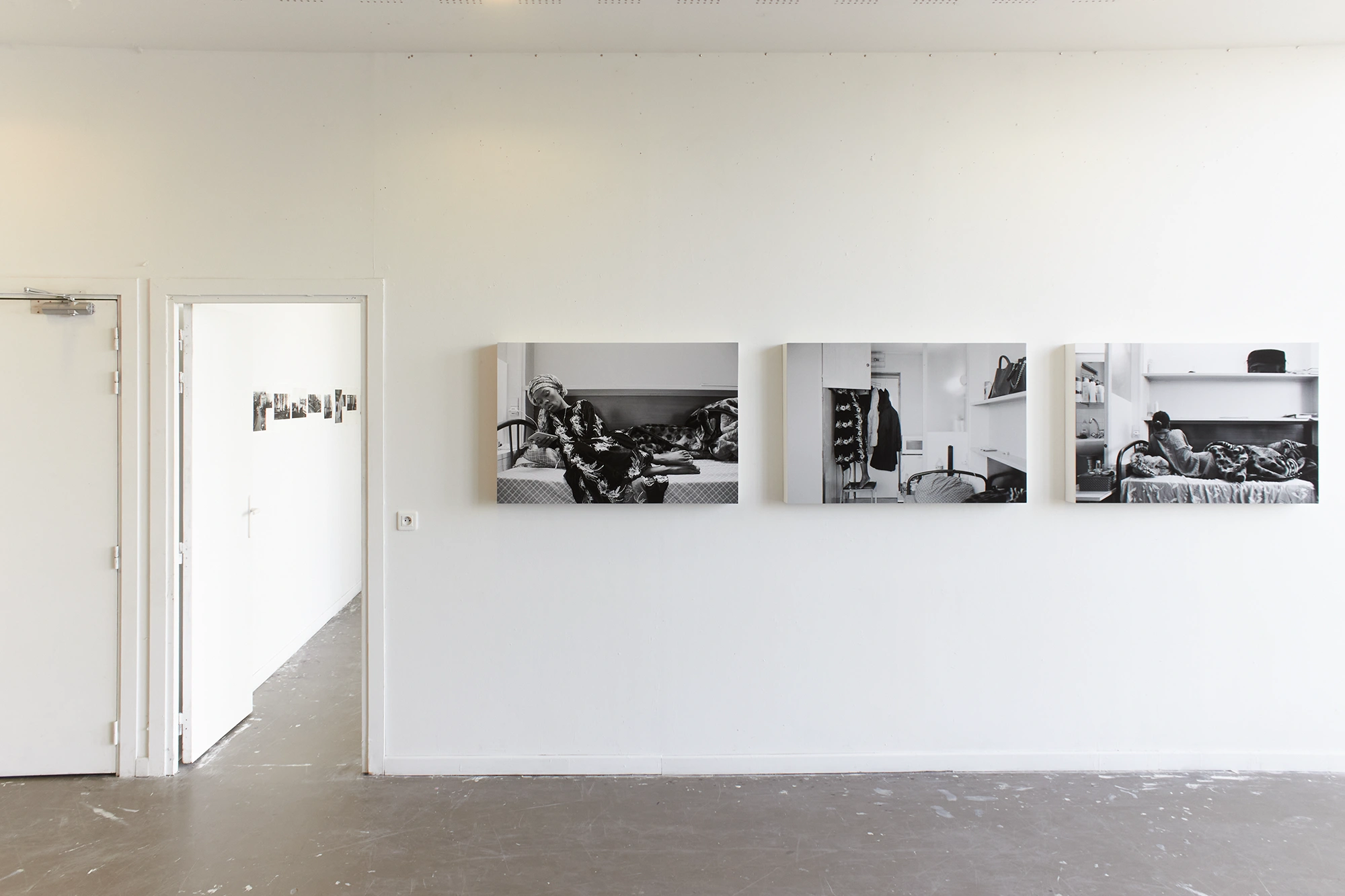 Aniruddha Biswas, Next Doors, 2020–2021, installation view of analogue photographs displayed on a white wall in an exhibition space.