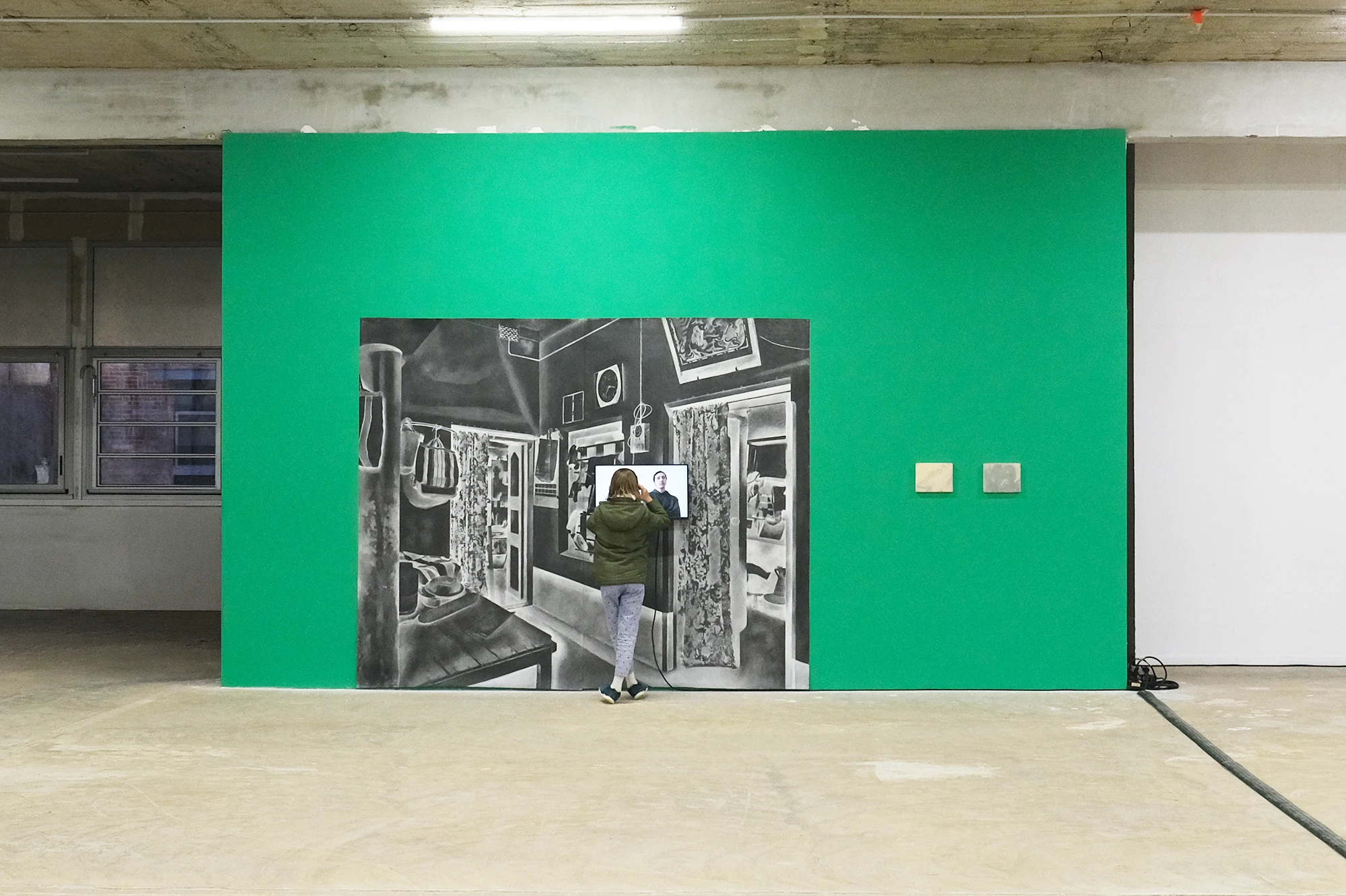 Aniruddha Biswas, Turning Back, 2023, installation view of a large charcoal drawing of a domestic interior with an integrated video screen.